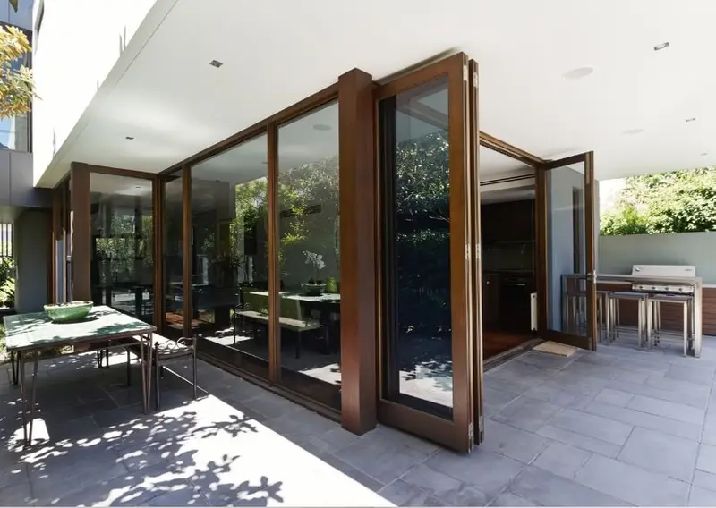 Large wooden folding doors opening onto a covered patio